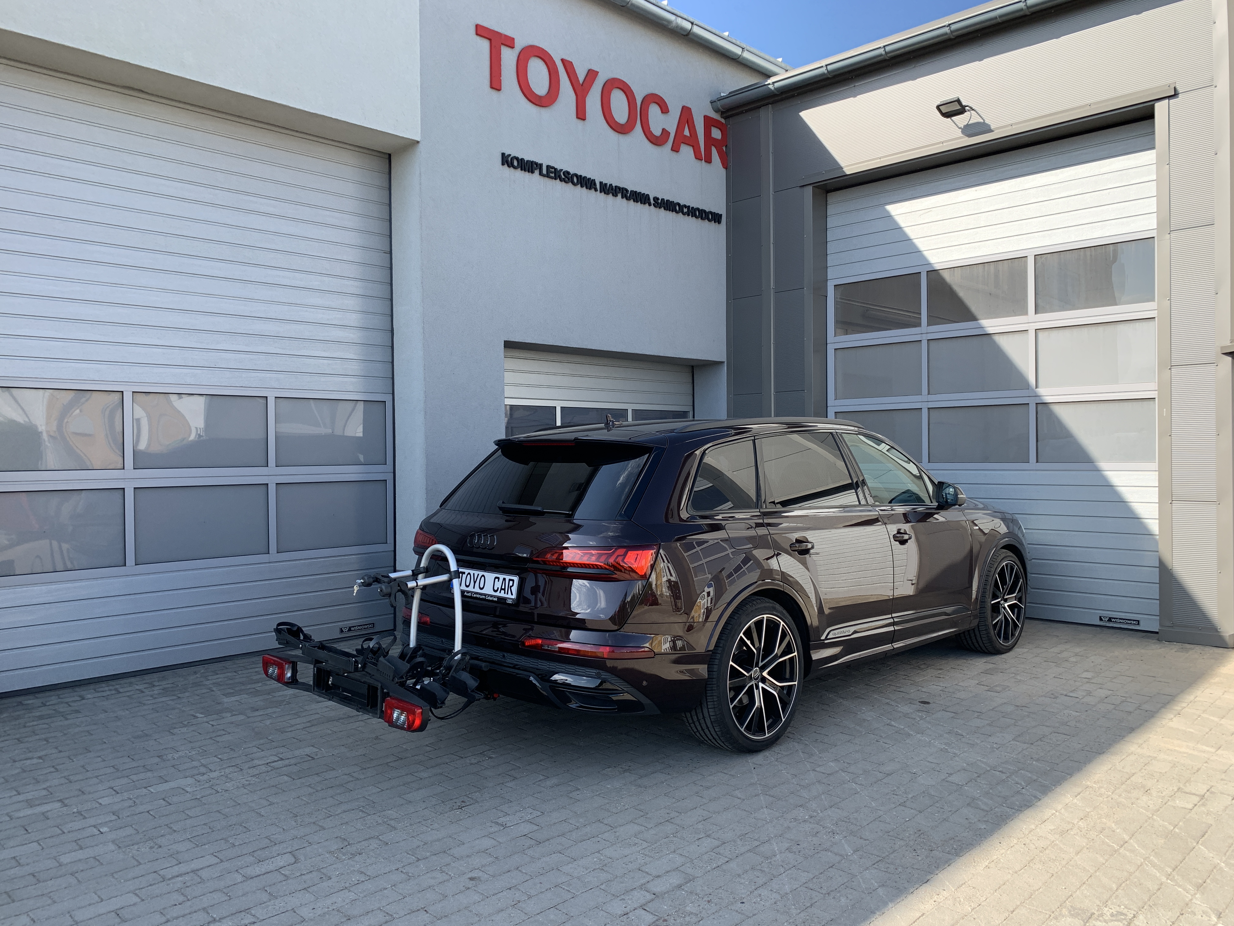 na zdjęciu samochód osobowy Audi Q7 4M0 z bagażnikiem rowerowym Westfalia BC60 zamontowanym na haku samochodu po montażu haka holowniczego 305437600001 w naszym serwisie montującym haki holownicze do aut w poznaniu 